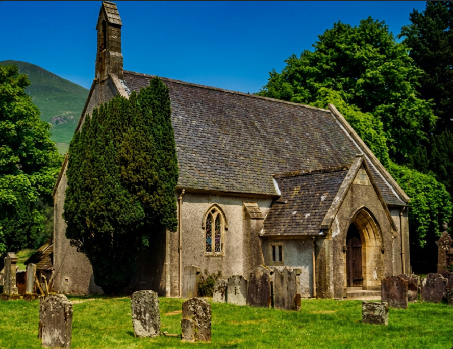 Ancient Scottish stone church above a sea loch at dawn